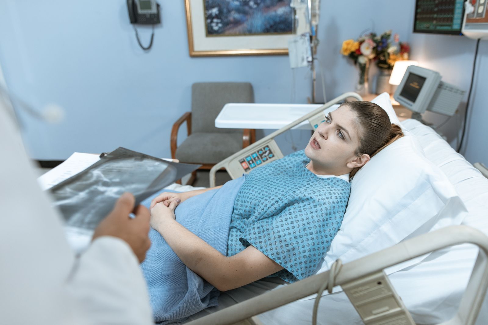 Une patiente allongée dans une chambre d'hôpital écoute le médecin